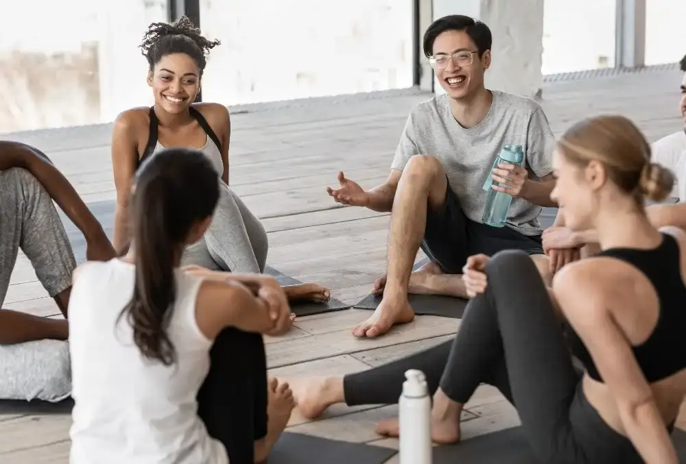 A group of people talking after a yoga class.